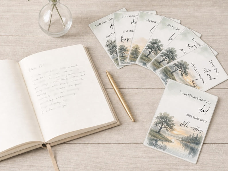 Open notebook with a gold pen and grief cards reading I will always love my dad and love does not end