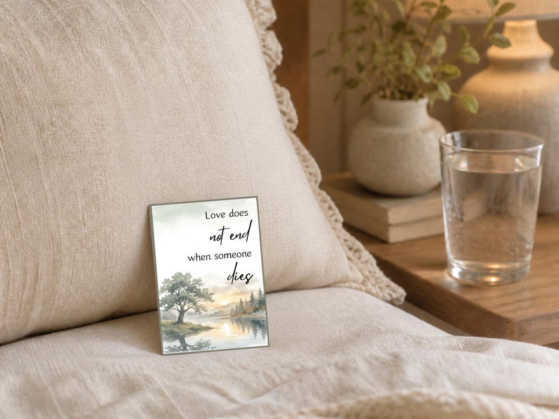Watercolor landscape card reading love does not end when someone dies on a beige surface