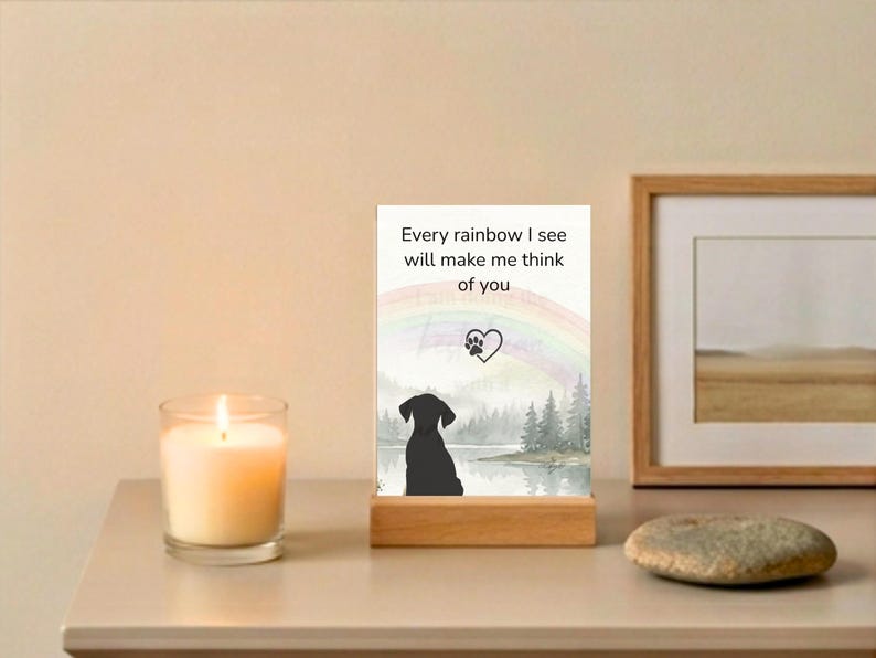 Memorial card reading every rainbow I see will make me think of you with a candle and framed art