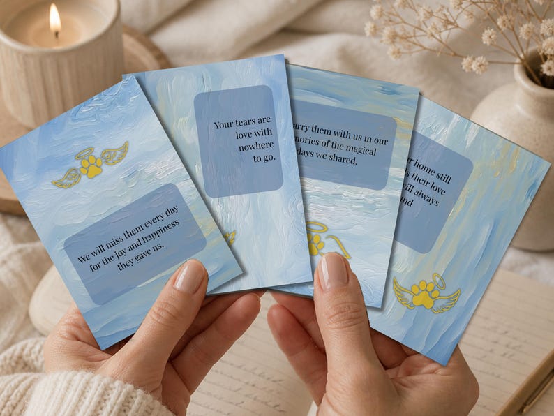 Hands holding a fan of dog loss affirmation cards beside a candle and flowers