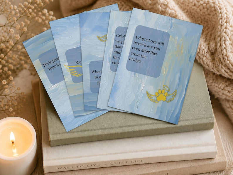 Cards fanned on a stack of books beside a lit candle and dried flowers