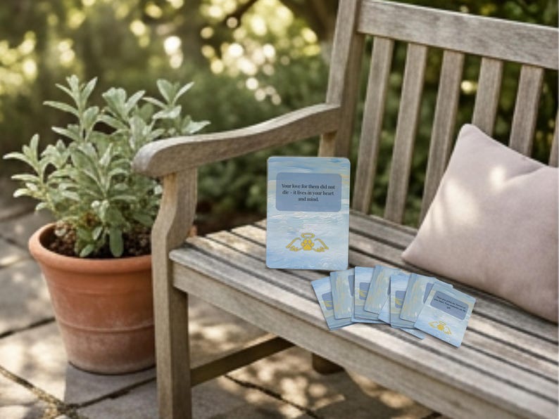 Cards displayed on a sunlit garden bench showing calming blue card backs and angel wing paw design